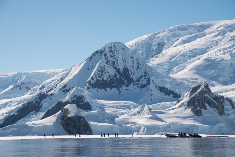 Hiking on the fast ice with dramatic mountain scenery